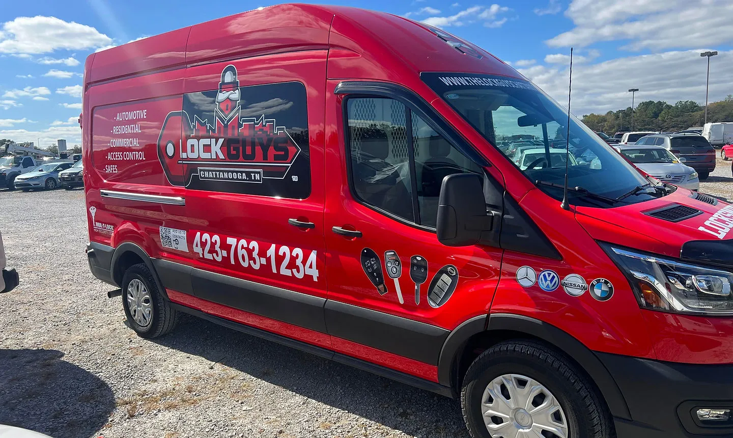 A red Lock Guys of Chattanooga service van, showing the logo, phone number and key services